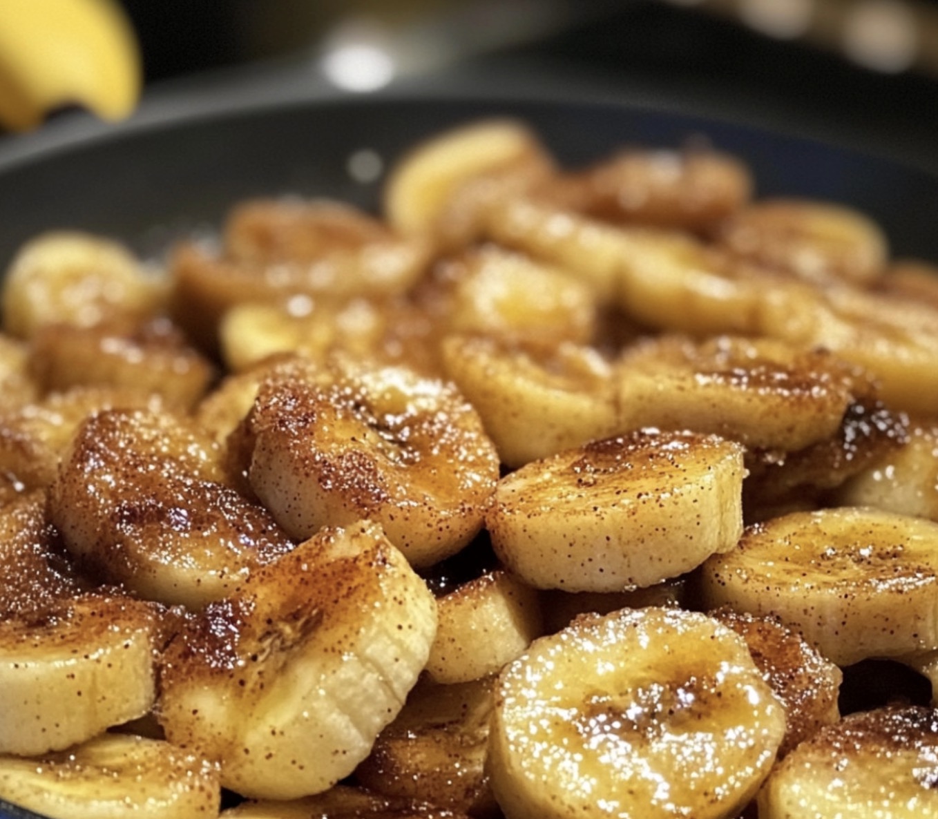 A bowl of sweet bananas with sugar sprinkled on top.
