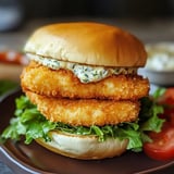 A bun with lettuce, mayo, and fish fillet.